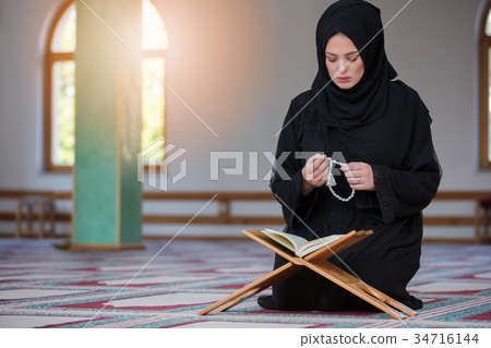 Young muslim woman praying in mosque Young muslim woman praying in mosque 34716144