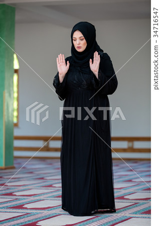 Young muslim woman praying in mosque 34716547