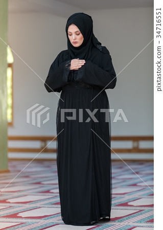 Young muslim woman praying in mosque 34716551