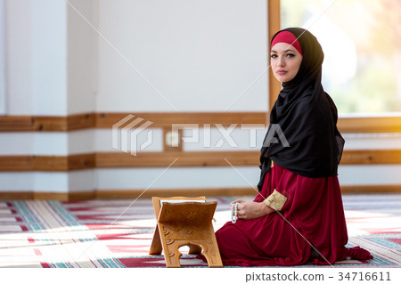 Young muslim woman praying in mosque 34716611