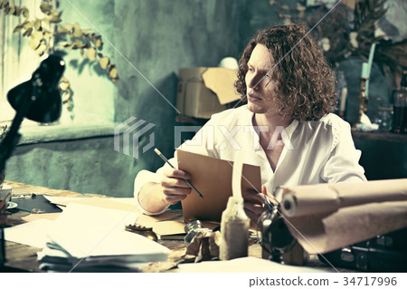 Writer at work. Handsome young writer sitting at 34717996