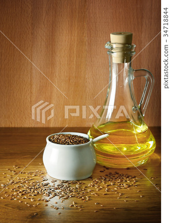 Linseed oil and flax seed on wooden background. 34718844
