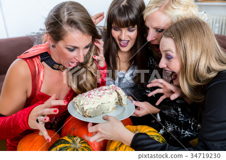 Four women wearing Halloween costumes while posing 34719230