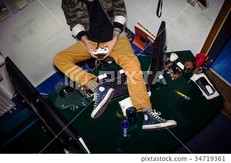 Teenager with video game addiction playing while 34719361