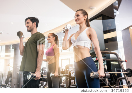 Three young people smiling while alternating Three young people smiling while alternating 34719363