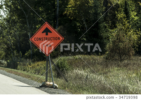 Orange construction worker sign at road into the 34719398