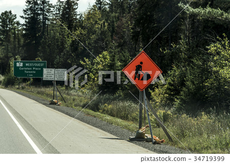 Orange construction worker sign at road into the 34719399