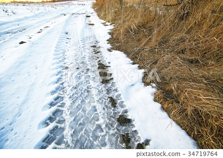 traces of the car wheels on a snowy road 34719764