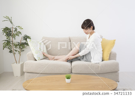 Woman massaging feet at home Woman massaging feet at home 34721133