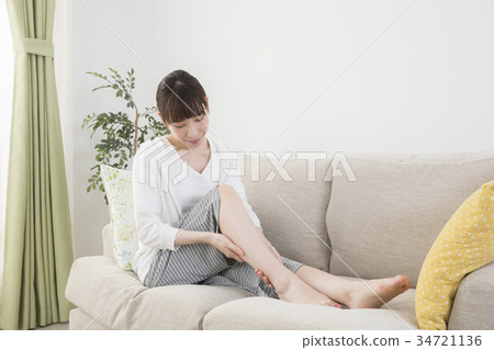Woman massaging feet at home Woman massaging feet at home 34721136