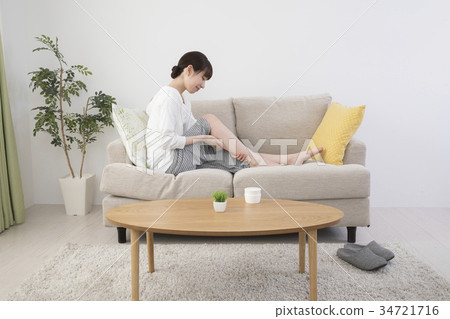 Woman massaging feet at home 34721716