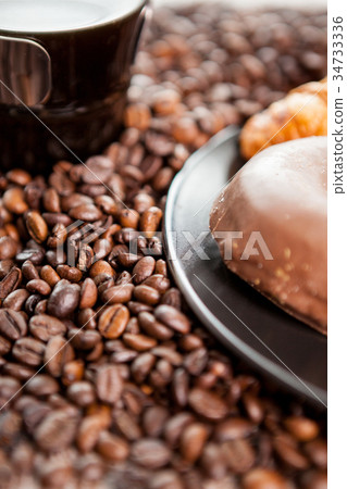Croissant and coffee beans in close up Croissant and coffee beans in close up 34733336