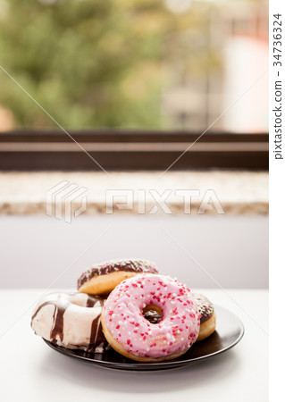 Plate with donuts next to window Plate with donuts next to window 34736324