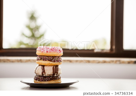 Plate with donuts next to window Plate with donuts next to window 34736334