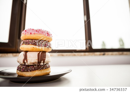 Plate with donuts next to window Plate with donuts next to window 34736337