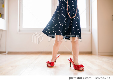 Unrecognizable little girl in dress and red high Unrecognizable little girl in dress and red high 34736783