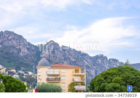 Daylight view to a hotel and big mountains in Beaulieu sur mer 34738019