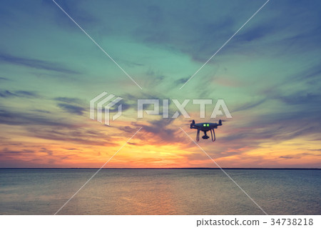 Silhouette of Drone Quad copter flying in sky 34738218