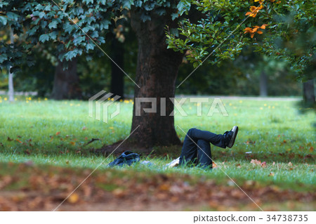Man have rest in summer park - laying on the grass Man have rest in summer park - laying on the grass 34738735