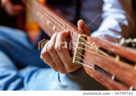 young woman playing guitar young woman playing guitar 34740743