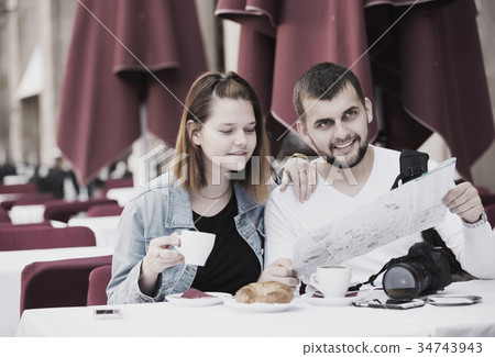 man and woman looking at map 34743943
