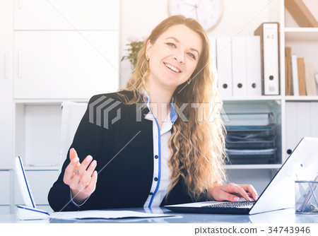 Young and smiling businesswoman in jacket 34743946