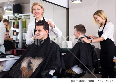 Mature female doing hairstyle for adult man 34743947