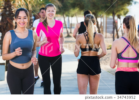 People running along embankment 34743952
