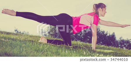Woman 20-30 years old is practising asanas in pink T-shirt 34744010