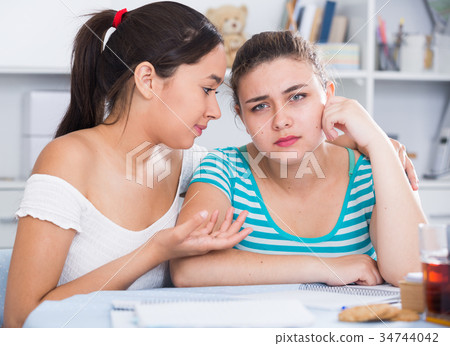 Female friend soothing sad girl 34744042