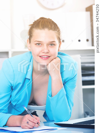 Office worker woman is signing agreement papers of financial nature 34744250