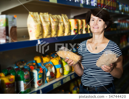Elderly woman buying groats 34744420