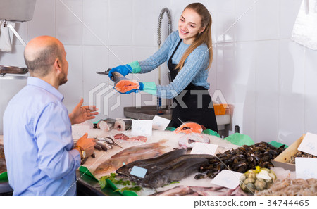male customer selecting cooled fish in local fishery male customer selecting cooled fish in local fishery 34744465