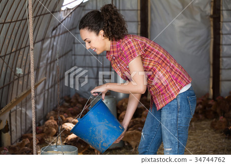 Positive female farmer carrying chickens 34744762