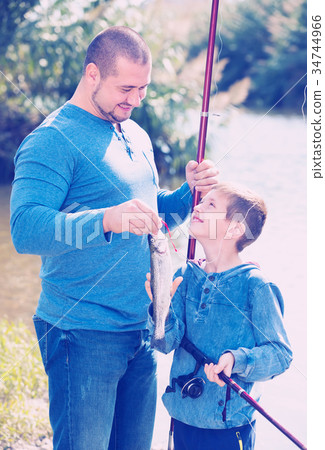 father and son fishing in wild river. 34744966