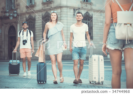 Cheerful man and woman in shorts with luggage 34744968