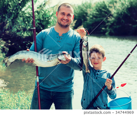 father and son fishing in wild river. 34744969