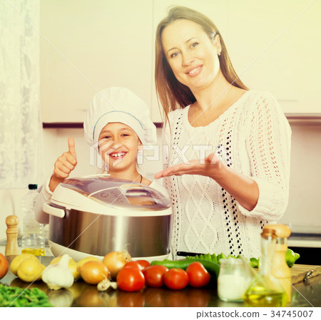 mother and daughter using multicooker 34745007