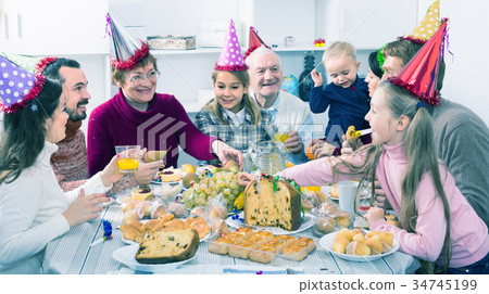 family proposing festive toasts during Christmas dinner 34745199