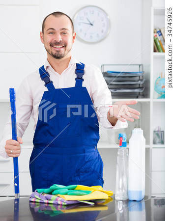 Young man in apron cleaning table Young man in apron cleaning table 34745926