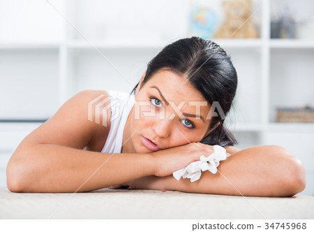 Young brunette woman wipes tears 34745968