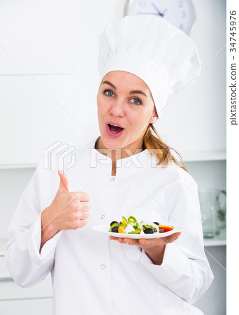 girl in chef's hat and white coat showing salad 34745976