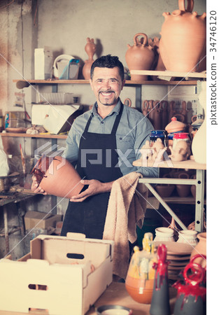 Craftsman with ceramic crockery 34746120