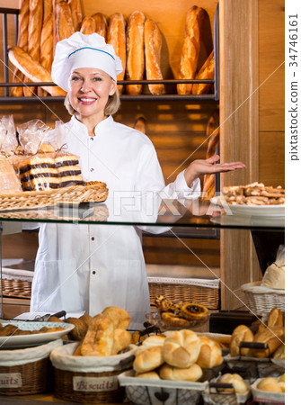 Mature woman selling fresh pastry and baguettes Mature woman selling fresh pastry and baguettes 34746161