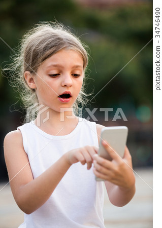 girl surprised looking at phone girl surprised looking at phone 34746490