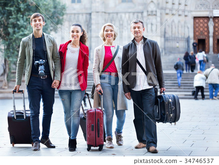 Happy family of four with trunks and bags 34746537