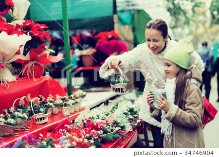 Happy woman with daughter buying Christmas floral composition Happy woman with daughter buying Christmas floral composition 34746904