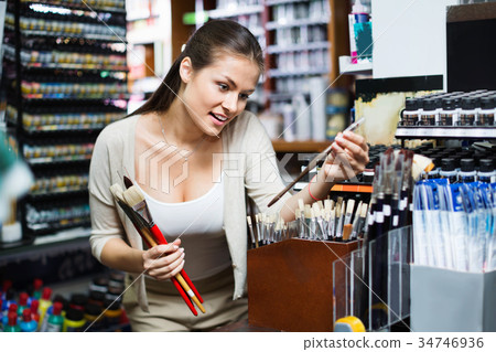 Portrait of cheerful woman choosing brushes for drawing Portrait of cheerful woman choosing brushes for drawing 34746936