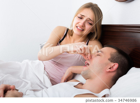Woman disturbed with partner snores. Woman disturbed with partner snores. 34746986