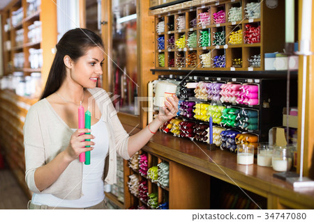 Portrait of young woman choosing candles 34747080